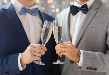 two men in suits clinking champagne glasses