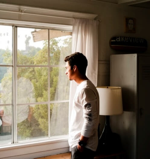 Man Looking Out Window