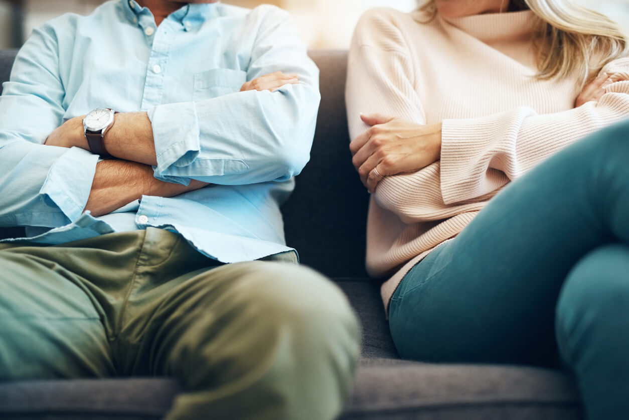 Couple sitting angrily next to eachother