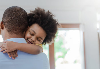 Father hugging son in living room