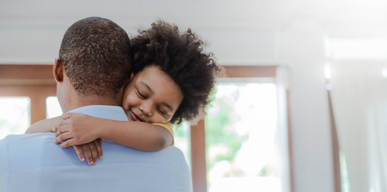 Father hugging son in living room