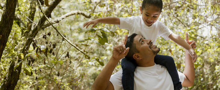 A young father giving his daughter a shoulder ride