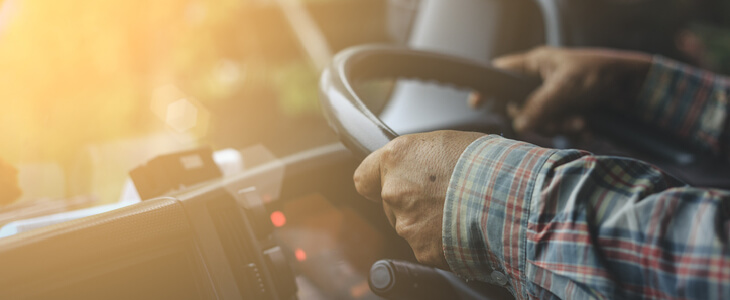 truck driver grasping both hands on a steering wheel