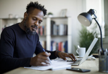Man sorting through finances on his laptop