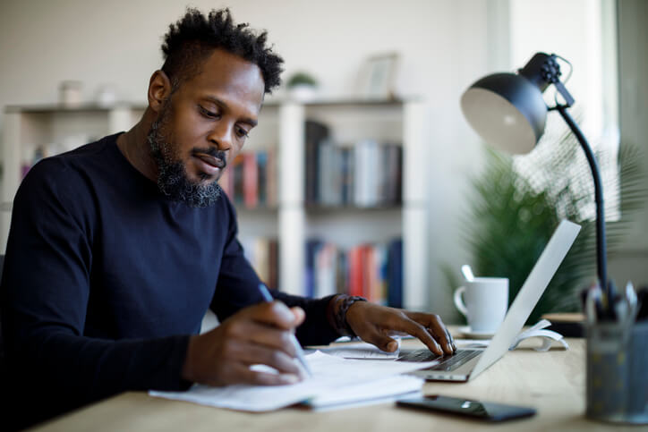 Man sorting through finances on his laptop