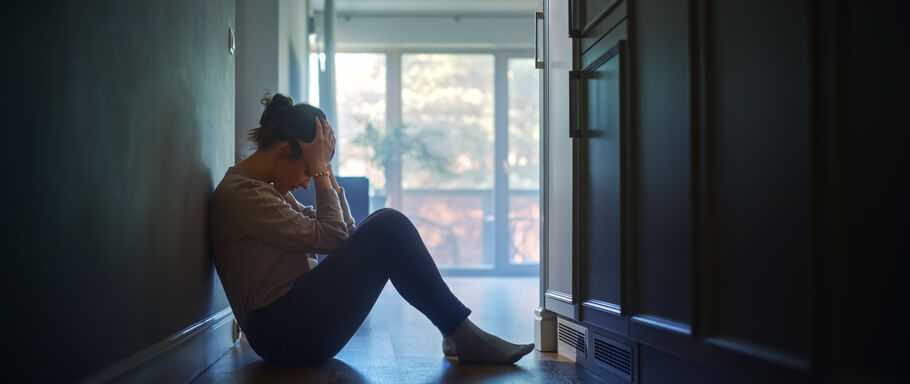 Sad Young Woman Sitting on the Floor In the Hallway of Her Appartment, Covering Face with Hands. Atmosphere of Depression, Trouble in Relationship, Death in the Family. Dramatic Bad News Moment