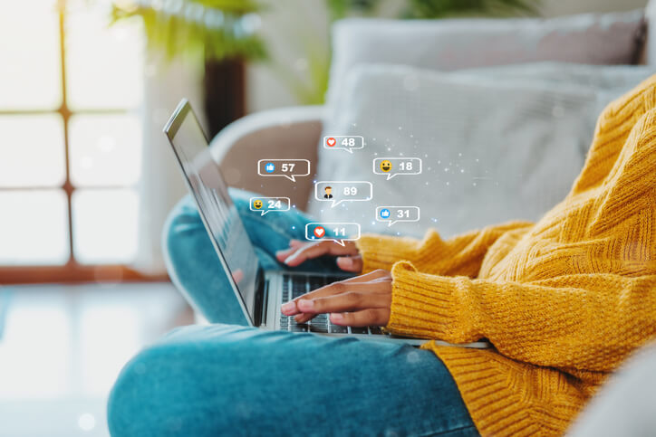 African American teenage woman using a smartphone ,Laptop with Icon communication network social media network pop notification concept.