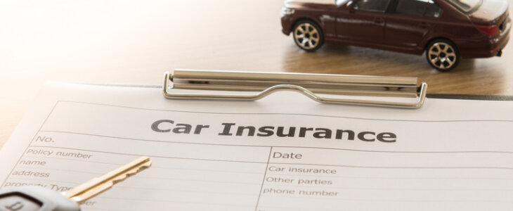 car insurance application form with car model and key remote on desk.