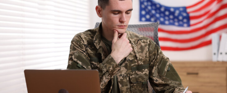 Military service. Young soldier working at table in office