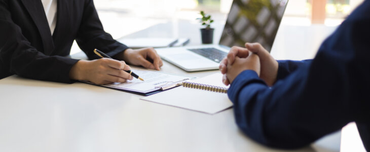 The manager is reading the resume and is interviewing the new employee. Negotiating business and signing a contract. Lawyer and legal advisor.