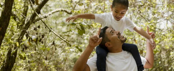 A young father giving his daughter a shoulder ride